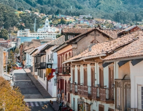 Vista panorámica del barrio La Candelaria en Bogotá con un taxi amarillo en primer plano.